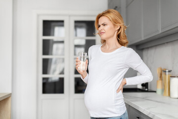Pregnant woman feeling unwell with glass of water