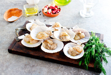From above fresh appetizing scallop with shell served on wooden boars - 786626157