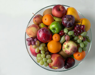 Fototapeta na wymiar A bowl of fruit with apples, oranges, and grapes. The bowl is full and colorful, and it looks like a healthy snack