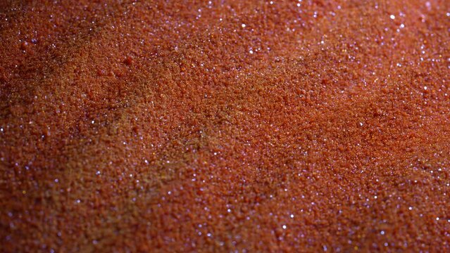 Small bright orange crystals of potassium dichromate, close up, abstract colorful background