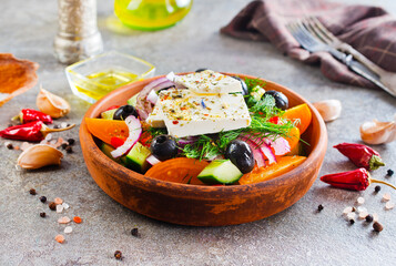 Greek salad of fresh cucumber, tomato, sweet pepper, lettuce, red onion, feta cheese and olives with olive oil. Healthy food, top view