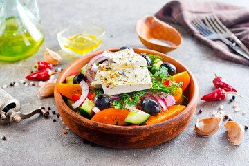 Greek salad of fresh cucumber, tomato, sweet pepper, lettuce, red onion, feta cheese and olives with olive oil. Healthy food, top view