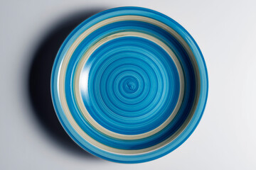 Elegant empty soup plate bowl colored with concentric blue brushstrokes