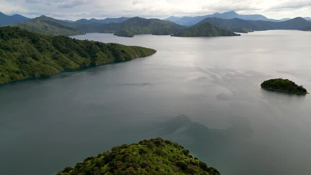Mountains surrounded by calm waterways and low moody clouds in Marlborough Sounds, New Zealand.  
