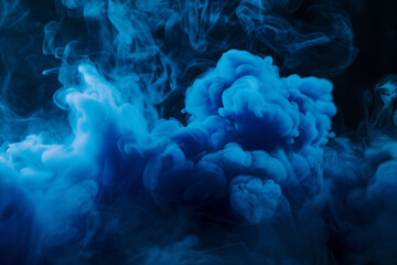 Fototapeta premium Blue powder explosion smoke drifts against a black background.