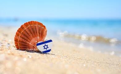 Sandy beach in Israel. Israel flag in the shape of a heart and a large shell. A wonderful seaside...