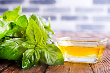 Basil oil and fresh herbs on wooden table - 786632947
