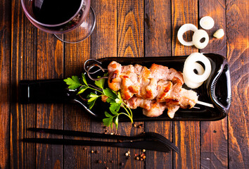 Grilled Lula kebab on skewers with spices in a black plate on a wooden background - 786633545