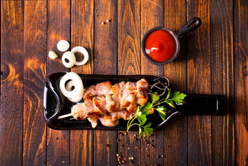 Grilled Lula kebab on skewers with spices in a black plate on a wooden background - 786633589