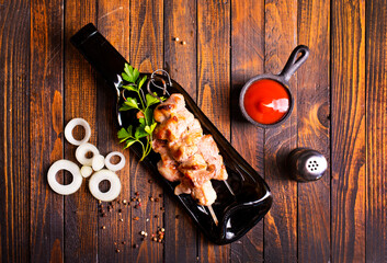 Grilled Lula kebab on skewers with spices in a black plate on a wooden background - 786633710