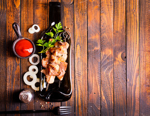 Grilled Lula kebab on skewers with spices in a black plate on a wooden background - 786633925