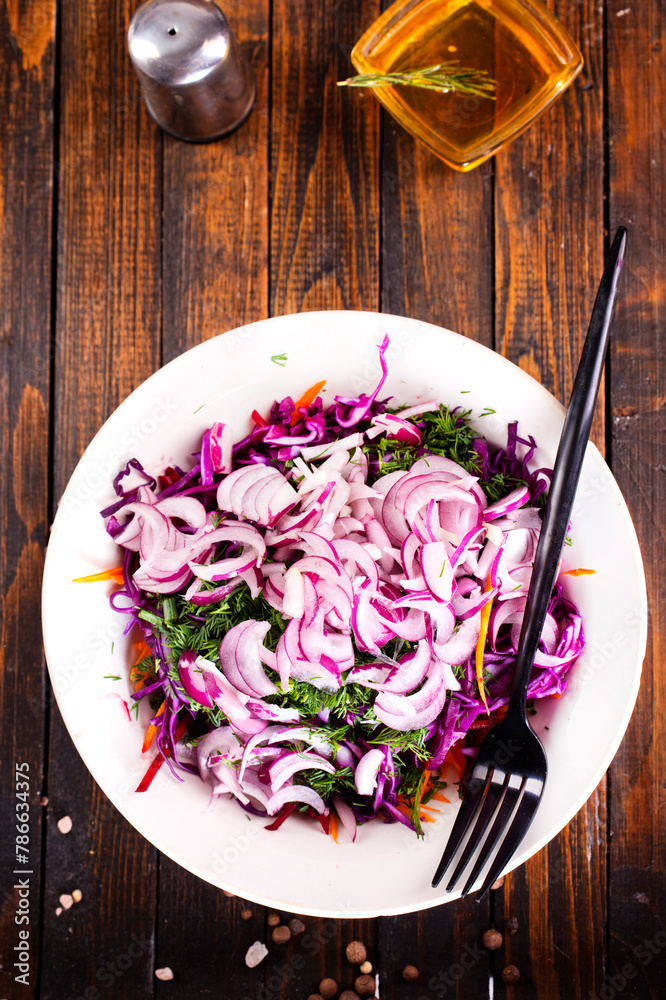 Sticker fresh salad with onion, tomatoes and mixed greens on wooden background top view. healthy food.