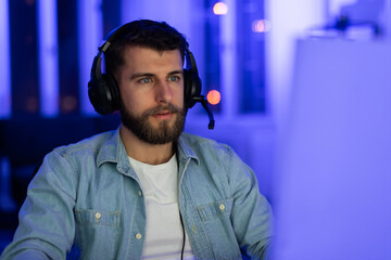 Focused gamer with headphones at home, closeup