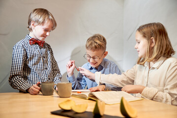 Children aged 10 - 12 years old do an interesting educational game together at the table.