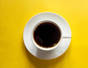 Obraz na płótnie Canvas A cup of black coffee on a yellow background.