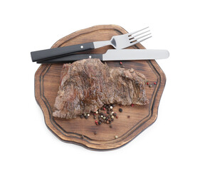 Piece of delicious grilled beef meat, peppercorns and cutlery isolated on white, top view