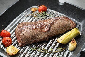 Delicious grilled beef meat and vegetables in pan, closeup