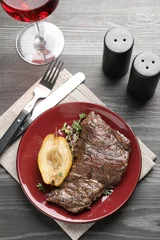 Poster Delicious roasted beef meat, caramelized pear and thyme served on grey wooden table, flat lay © New Africa
