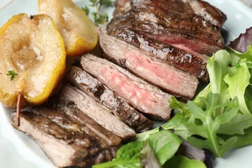 Fotobehang Pieces of delicious roasted beef meat, caramelized pear and greens on plate, closeup © New Africa