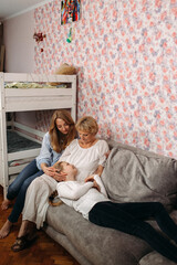 Obraz premium Two Women Sitting on Couch With Baby