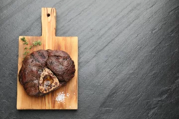 Fotobehang Piece of delicious grilled beef meat, thyme and salt on black table, top view. Space for text © New Africa