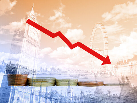 Piles of British coins with decreasing graph of UK currency