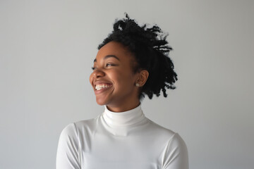 Obraz premium Dark-skinned girl with a beautiful smile in a white turtleneck on a white background