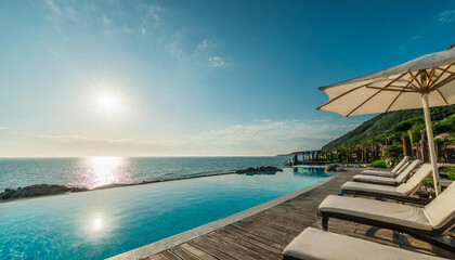 Obraz premium Sea view. Luxury modern white beach hotel with swimming pool at sunset. Sunbed on sundeck for vacation home or hotel resort