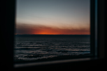 Tranquil seaside sunset view through window in Larino, Galicia