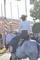 A woman riding a horse in the world famous April fair of Seville, Andalusia, Spain