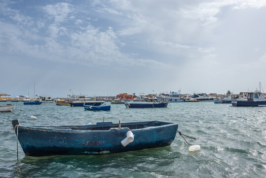 Boats in port of Marzamemi village on the island of Sicily, Italy. Brancati Islet on background