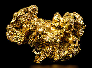 Gold nugget isolated on a black background. Gold ore as finance and business concept.