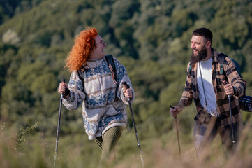 A beautiful and cheerful couple is hiking in the mountains, enjoying nature and each other's company