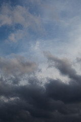 Transition from dark clouds to bright sky, weather change, vertical shot, close-up.