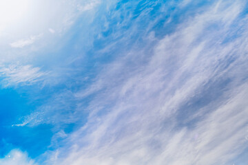 Mystical sky with clouds, haze of light and clouds in the blue sky, unusual colors on the clouds in the sky