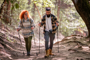 A beautiful and cheerful couple is hiking in the forest enjoying nature and each other's company - 786662910