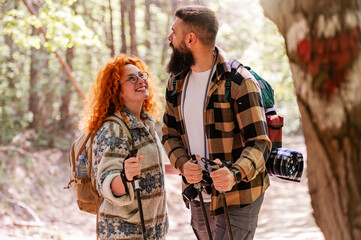 A beautiful and cheerful couple is hiking in the forest enjoying nature and each other's company - 786663721