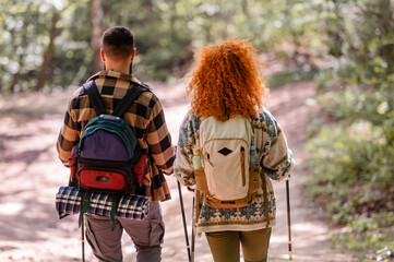 A beautiful and cheerful couple is hiking in the forest enjoying nature and each other's company - 786664926