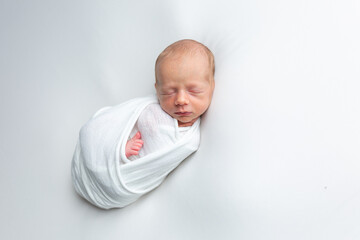 Top view of Newborn baby sleeping with blanket on white bed. Infant lying on white bed. African American newborn baby