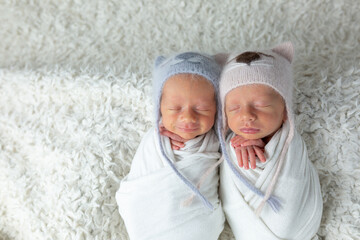 Twins. newborn twin boys on a white background in hats. newborn photo session