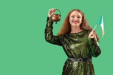 Young woman with Irish flag and Leprechaun's pot on green background. St. Patrick's Day celebration