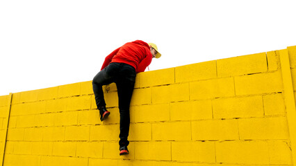 Climbing a bright yellow wall under a clear sky