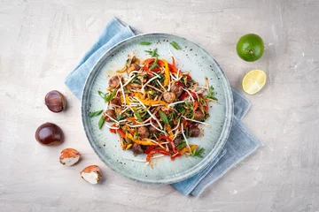 Rolgordijnen Traditional Asian wok spinach with chestnuts, pepper strips and soy sprouts served as top view in a Nordic design plate with copy space © HLPhoto