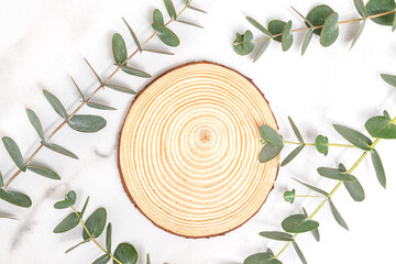 Wooden podium with eucalyptus decoration on white