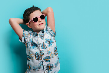 Young boy relaxing in tropical shirt and sunglasses