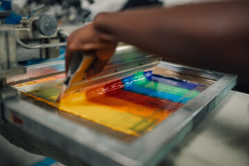 Obraz premium Close up of interracial press woman's hands silk screen printing.