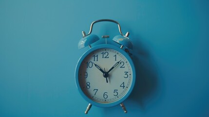 A blue alarm clock hanging on a blue wall. Suitable for time management concepts