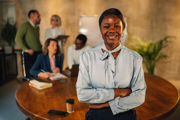 Fototapeta na wymiar Interracial businesswoman smiling at camera on meeting at boardroom.
