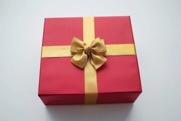 A red gift box with a shiny gold bow. Perfect for holiday and celebration concepts