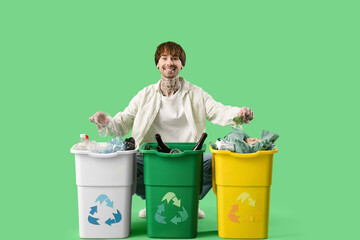 Young man with containers for garbage sorting rubbish on green background. Recycling concept